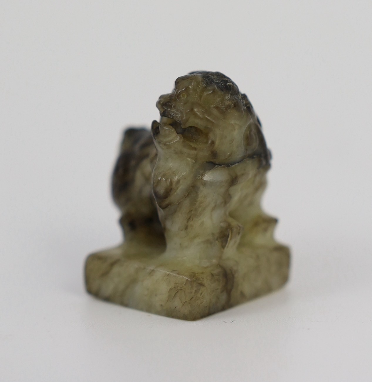 A Chinese pale celadon and black jade ‘lion-dog’ seal, 18th/19th century, 3.9cm high